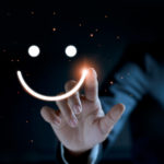 Finger of businessman touching and drawing face emoticon smile on dark background, service mind, service rating. Satisfaction and  customer service concept.