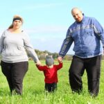 Overweight parents with her son walking together.