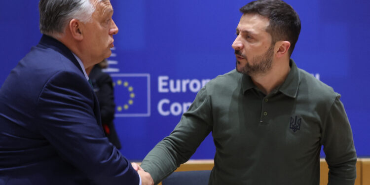 Hungarian Prime Minister Viktor Orban (L) shakes hands with Ukraine's President Zelensky during the European Council Summit at the EU headquarters in Brussels on June 27, 2024. (Photo by Olivier HOSLET / POOL / AFP)