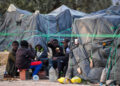 Migrants from sub-Saharan Africa sit next to makeshift shelters at a camp al-Amra on the outskirts of the Tunisian port city of Sfax on April 23, 2024. After President Kais Saied said in a speech last year that "hordes of illegal migrants" posed a demographic threat to Tunisia, anti-migrant violence broke out and hundreds of sub-Saharan Africans were kicked out of their jobs and homes. (Photo by Fethi Belaid / AFP)
