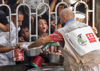 Palestinian children wait for a meal at a charity kitchen in the Mawasi area of Khan Yunis in the southern Gaza Strip on July 22, 2025. (Photo by AFP)