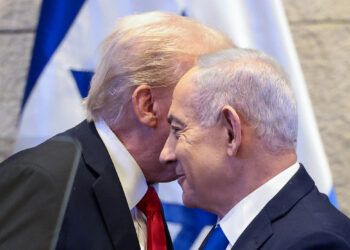 US President Donald Trump (L) whispers to Israeli Prime Minister Benjamin Netanyahu at the Israeli parliament, the Knesset, in Jerusalem on October 13, 2025. (Photo by Evelyn Hockstein / POOL / AFP)