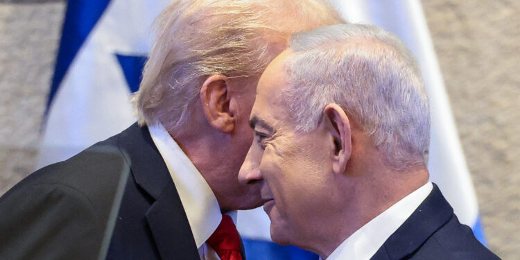 US President Donald Trump (L) whispers to Israeli Prime Minister Benjamin Netanyahu at the Israeli parliament, the Knesset, in Jerusalem on October 13, 2025. (Photo by Evelyn Hockstein / POOL / AFP)