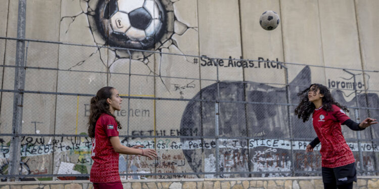 Palestinian football player Nour Abu Ghneim, 16, trains with a teammate at the Aida refugee camp stadium in Bethlehem in the occupied West Bank on January 29, 2026. The stadium, located near Israels separation barrier, features a graffiti mural of a football and faces the risk of demolition by Israeli authorities, who say it was built without a permit.//MIDDLEEASTIMAGES_MEI-PSE-MS-ARCWB-20260129-006/Credit:Mosab Shawer/MEI/SIPA/2602081214