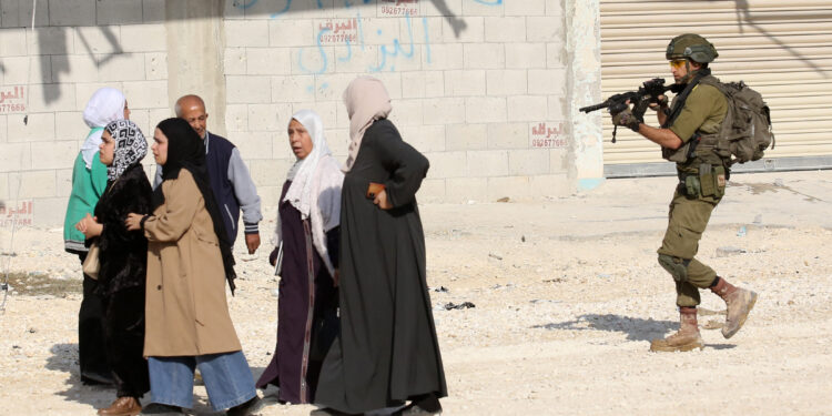 An Israeli soldier tries to prevent Palestinians from reaching their houses in Nur Shams refugee camp in the West Bank city of Tulkarm, Nov. 18, 2025. Palestinians took part in a demonstration demanding the right to return to their houses at the entrance of Nur Shams refugee camp, while Israeli soldiers assaulted the crowd and forced them to leave the area. [Photo by Nidal Eshtayeh/Xinhua/ABACAPRESS.COM, via IPA agency]