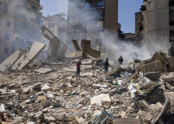 March 18, 2026, Beirut, Lebanon: Journalists report as smoke rises from a residential building leveled by an early-morning Israeli attack in central Beirut, Lebanon. At least 12 people have been killed and 41 injured by Israel's attacks targeting central Beirut this morning. More than a million people have been displaced since the war began. (Credit Image: © Daniel Carde/ZUMA Press Wire/IPA)