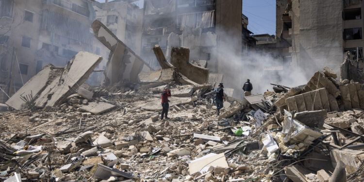 March 18, 2026, Beirut, Lebanon: Journalists report as smoke rises from a residential building leveled by an early-morning Israeli attack in central Beirut, Lebanon. At least 12 people have been killed and 41 injured by Israel's attacks targeting central Beirut this morning. More than a million people have been displaced since the war began. (Credit Image: © Daniel Carde/ZUMA Press Wire)