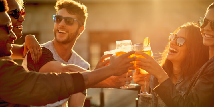 Together is our favorite place to be. a group of young diverse friends having a drink and spending the day outside on a rooftop.