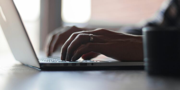 Mani scrivono al PC. Crediti: Thomas Lefebvre via Unsplash