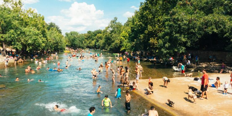 Persone fanno il bagno in un fiume. Crediti: Tomek Baginski via Unsplash