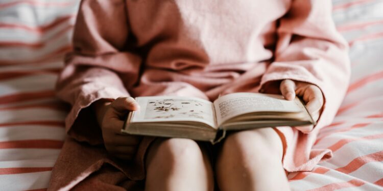 Bambina legge libro. Crediti: Annie Spratt via Imagoeconomica